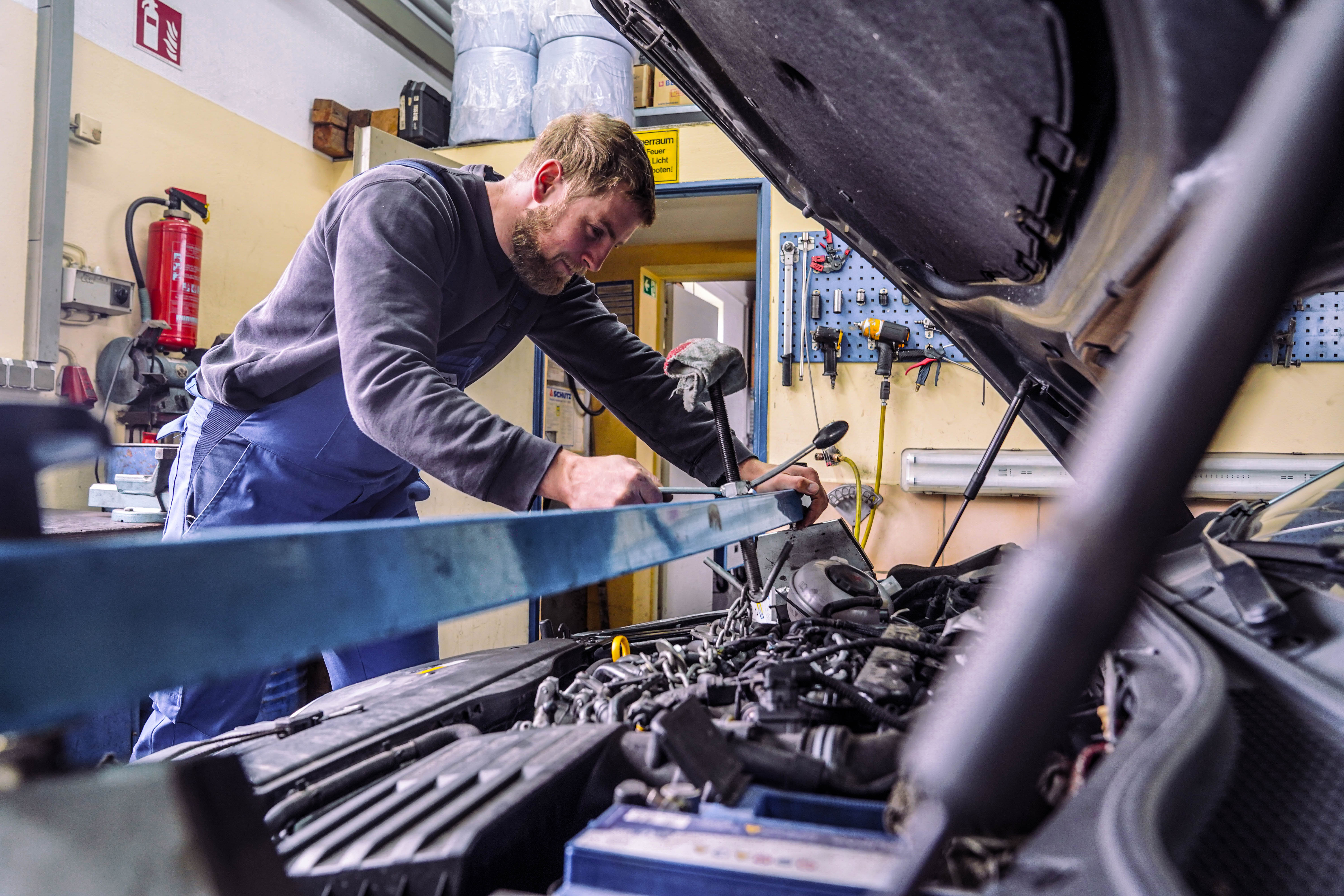 Mechatroniker arbeitet mit Werkzeug am Motor